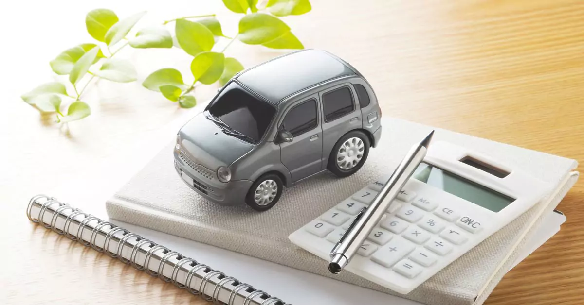 A small toy car and a calculator on top of two notebooks
